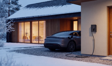 Elbil som laddas med en Zaptec Go 2-laddbox på fasaden till en villa en snöig vinterkväll.